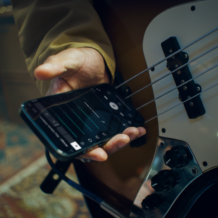 A musician adjusting tracks in the Moises mobile app
